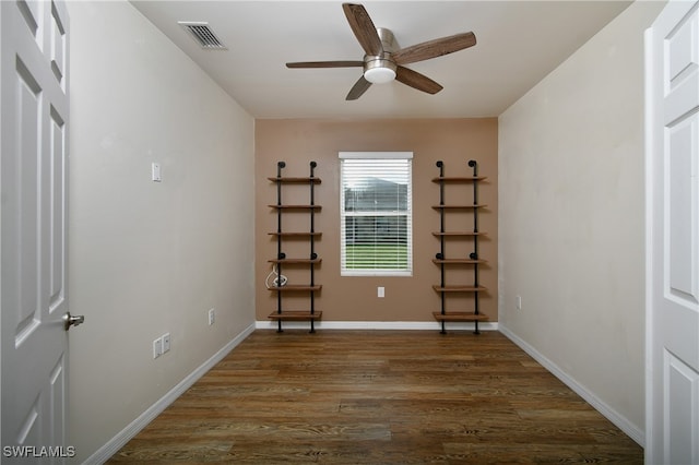 empty room with dark wood-type flooring and ceiling fan