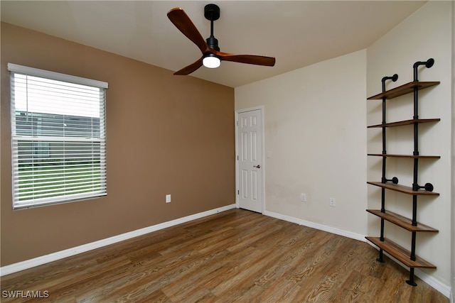 spare room with wood-type flooring, ceiling fan, and a healthy amount of sunlight