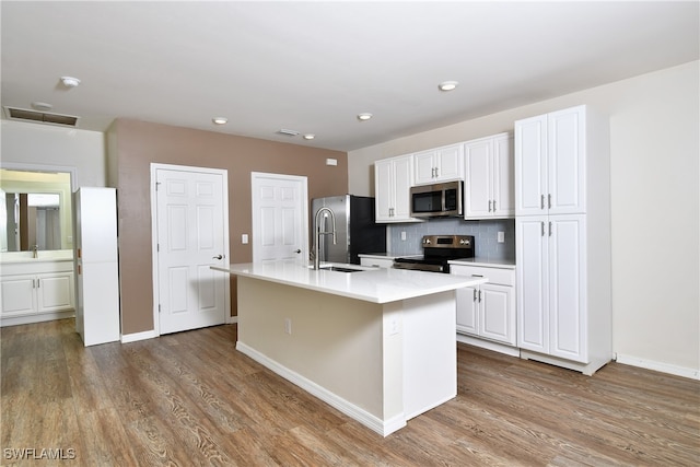 kitchen featuring light hardwood / wood-style floors, stainless steel appliances, an island with sink, and white cabinetry