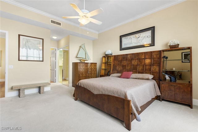 bedroom featuring ornamental molding, connected bathroom, light colored carpet, and ceiling fan