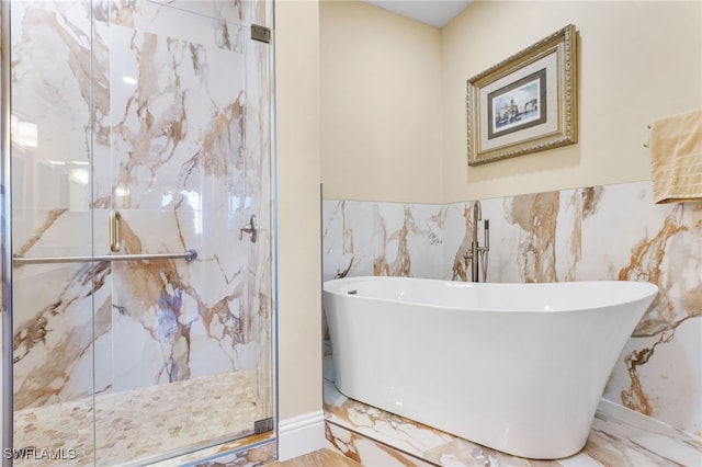 full bathroom with marble finish floor, a marble finish shower, and a freestanding bath