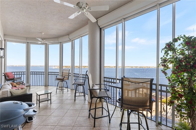 14200 Royal Harbour Ct Unit 1002, Fort Myers, FL 33908 - sunroom / solarium featuring a water view, a textured ceiling, plenty of natural light, and tile patterned floors