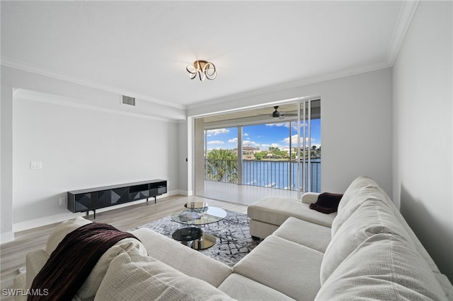 living room with light wood-type flooring, a water view, and ornamental molding