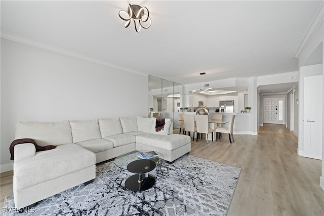 living room with light wood-type flooring and ornamental molding