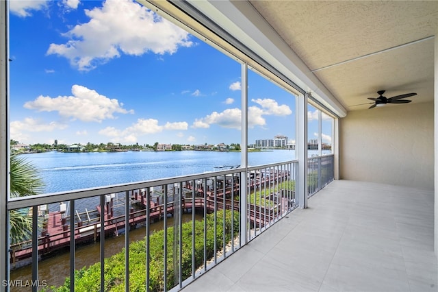 balcony with a water view and ceiling fan