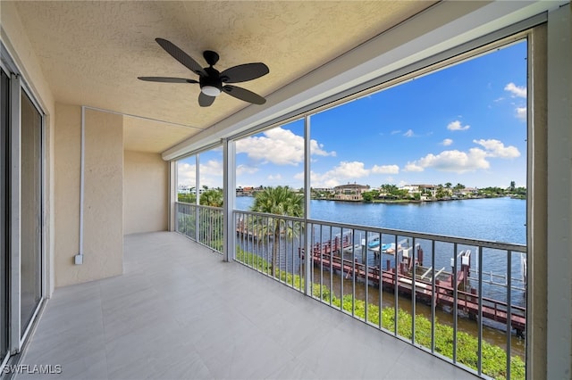 balcony featuring a water view and ceiling fan