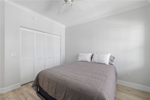 bedroom with light wood-type flooring, a closet, ceiling fan, and ornamental molding