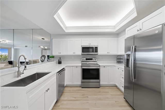 kitchen with light wood-type flooring, appliances with stainless steel finishes, white cabinetry, and sink