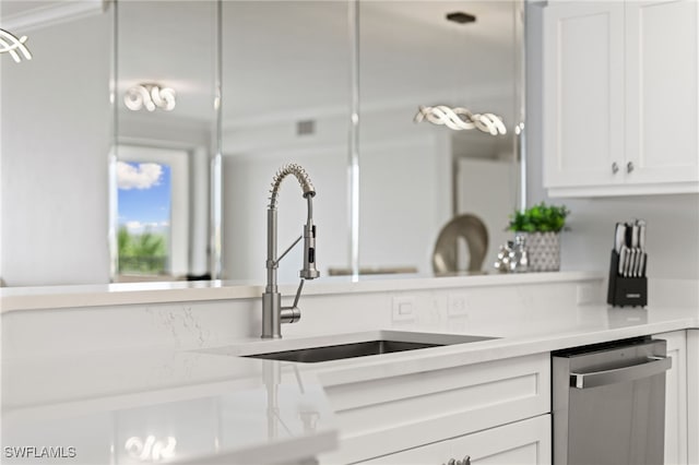 kitchen with dishwasher, white cabinetry, and sink