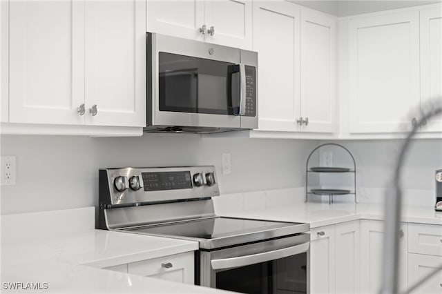 kitchen featuring stainless steel appliances and white cabinets