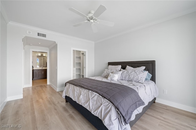 bedroom with crown molding, ceiling fan, a closet, a spacious closet, and light hardwood / wood-style floors