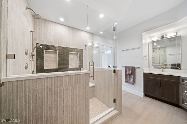 bathroom with walk in shower, wood-type flooring, and vanity