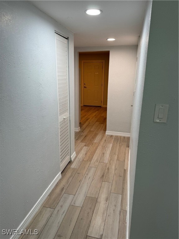 hallway with light hardwood / wood-style floors