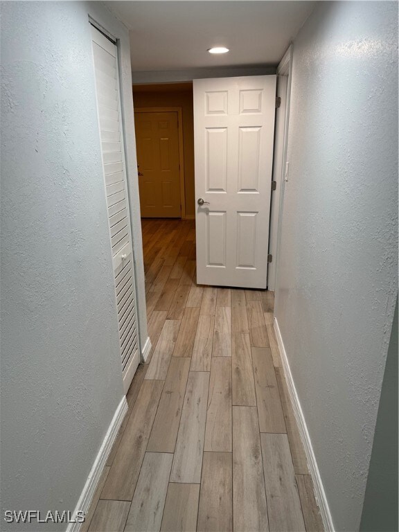 corridor with light hardwood / wood-style floors