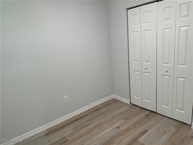 unfurnished bedroom with a closet and light hardwood / wood-style flooring