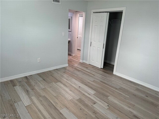 unfurnished bedroom featuring a closet and light hardwood / wood-style flooring