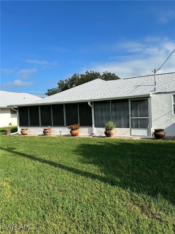 back of house with a sunroom and a yard