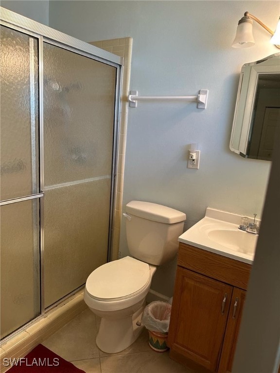 bathroom featuring vanity, toilet, walk in shower, and tile patterned floors