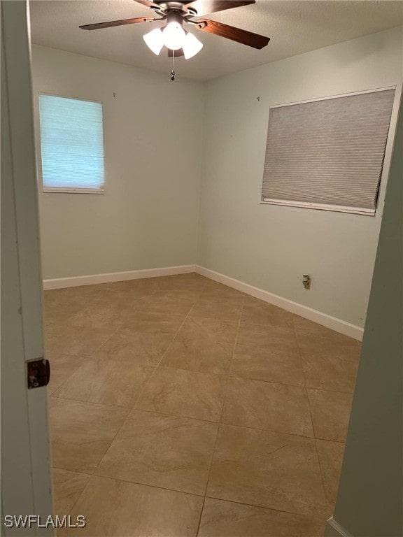 empty room with tile patterned flooring and ceiling fan