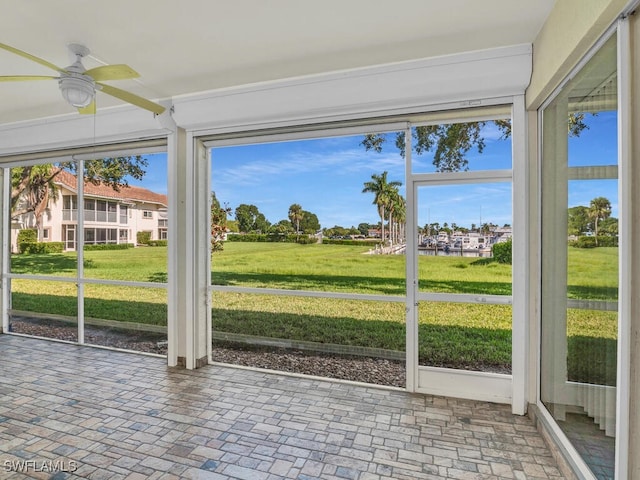 unfurnished sunroom featuring ceiling fan