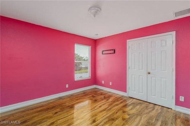 unfurnished bedroom featuring hardwood / wood-style floors and a closet