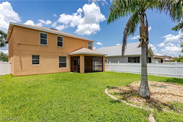 back of property with a yard and a sunroom