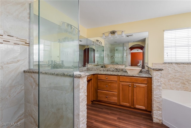 bathroom featuring tile walls, independent shower and bath, hardwood / wood-style flooring, and vanity