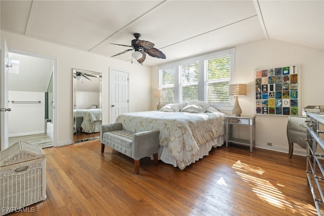 bedroom featuring connected bathroom, hardwood / wood-style floors, vaulted ceiling, and ceiling fan