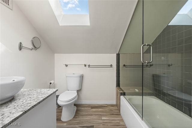 full bathroom with wood-type flooring, toilet, enclosed tub / shower combo, vaulted ceiling with skylight, and vanity