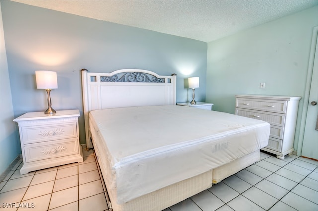 bedroom featuring a textured ceiling and light tile patterned floors