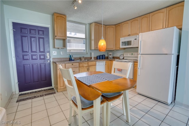 kitchen featuring a textured ceiling, light brown cabinetry, light tile patterned floors, and white appliances