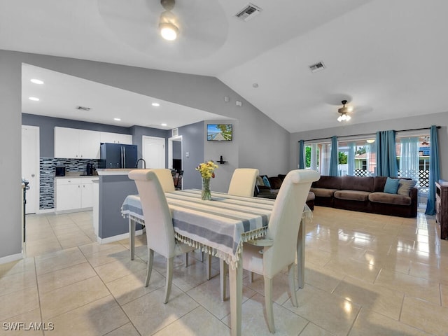 tiled dining area featuring lofted ceiling and ceiling fan