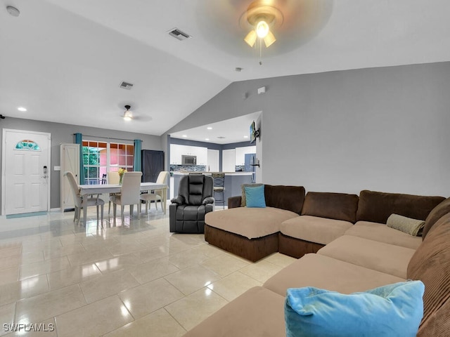 living room with lofted ceiling, ceiling fan, and light tile patterned flooring