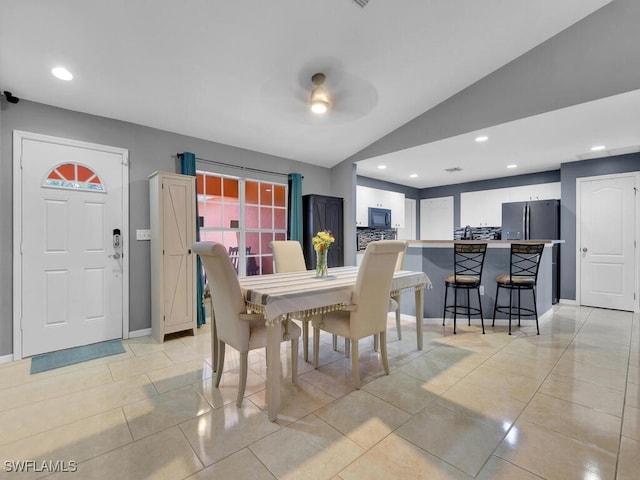 tiled dining room with lofted ceiling and ceiling fan