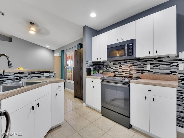 kitchen featuring black electric range, light tile patterned floors, tasteful backsplash, sink, and white cabinetry