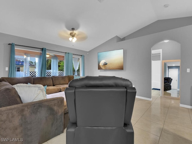 living room featuring ceiling fan, light tile patterned floors, and vaulted ceiling