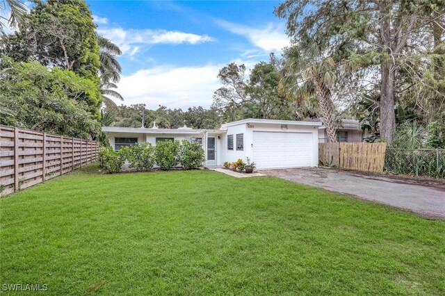 ranch-style home with a garage and a front lawn