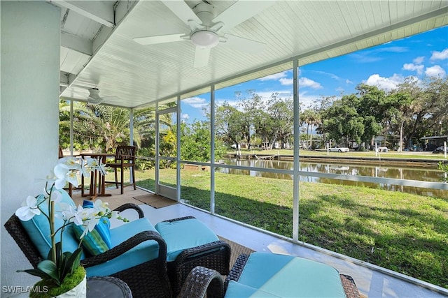 sunroom / solarium featuring a water view and a ceiling fan