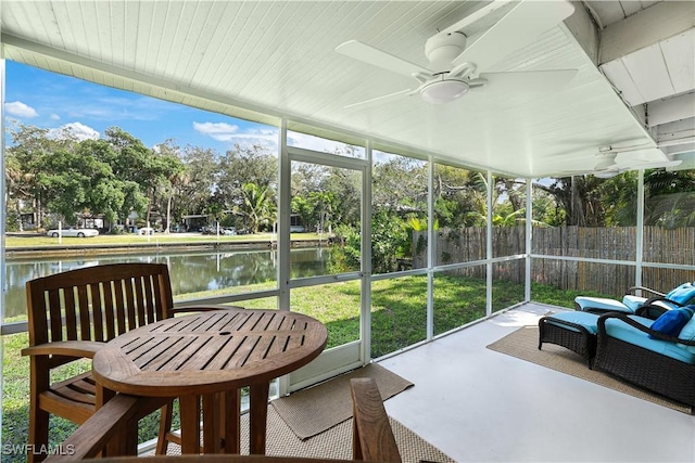 sunroom / solarium featuring a water view and a ceiling fan