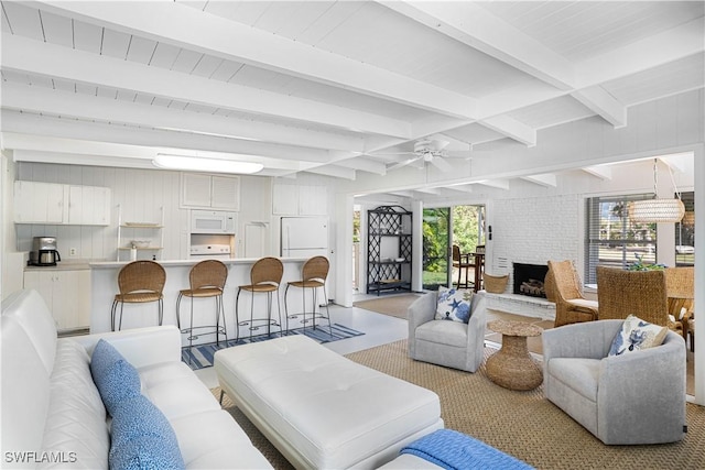 living area with a ceiling fan and beam ceiling