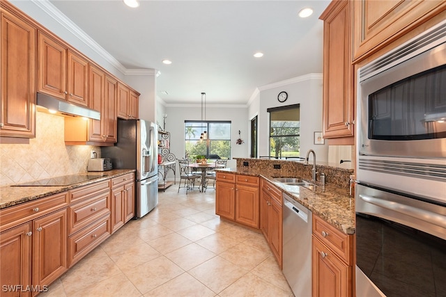 kitchen with light stone counters, sink, pendant lighting, crown molding, and stainless steel appliances