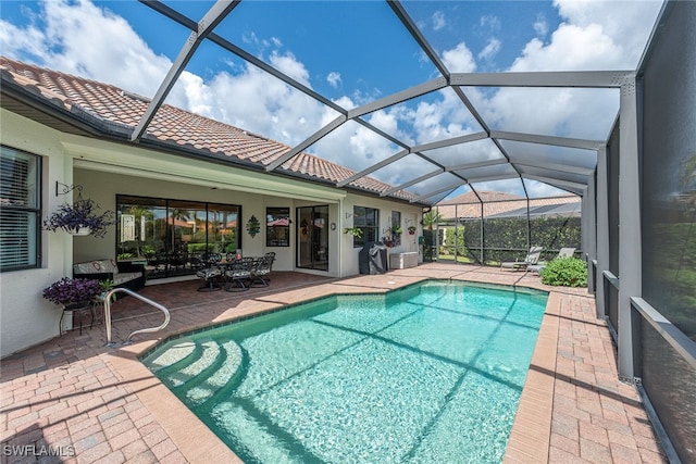 view of pool with a patio and glass enclosure