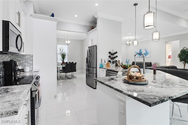 kitchen featuring white cabinetry, tasteful backsplash, stainless steel appliances, and hanging light fixtures