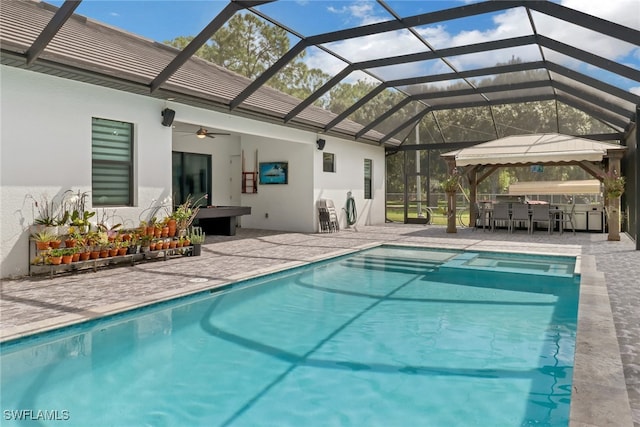 view of swimming pool featuring ceiling fan, a lanai, a patio area, and exterior bar