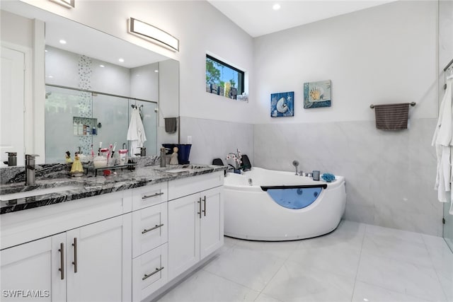 bathroom with vanity, separate shower and tub, and tile walls