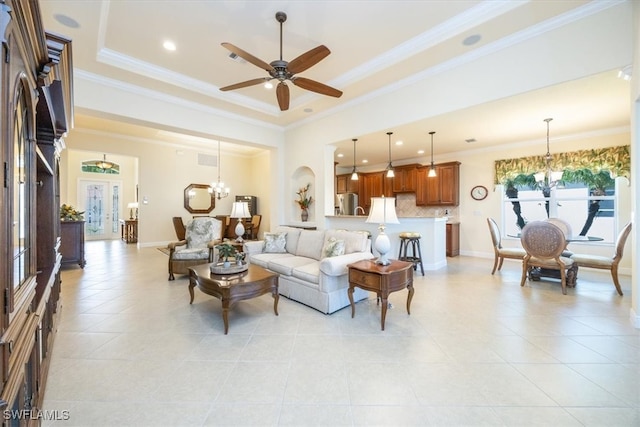 living room with french doors, crown molding, ceiling fan with notable chandelier, and a tray ceiling