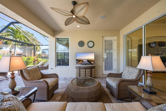 view of patio featuring a lanai, ceiling fan, and an outdoor living space