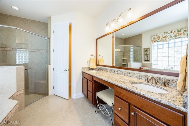 bathroom with a shower with door, tile patterned floors, and vanity