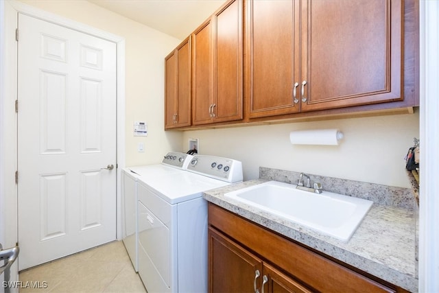 clothes washing area featuring sink, cabinets, washer and clothes dryer, and light tile patterned flooring