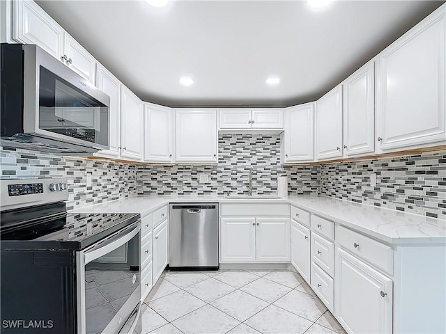4802 Albacore Ln, Fort Myers, FL 33919 - kitchen with backsplash, light stone counters, white cabinets, stainless steel appliances, and a sink